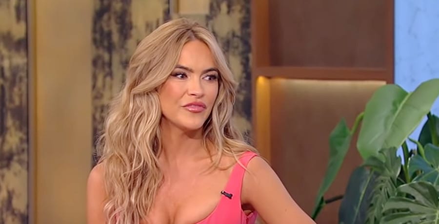 A woman with blonde hair and a pink dress