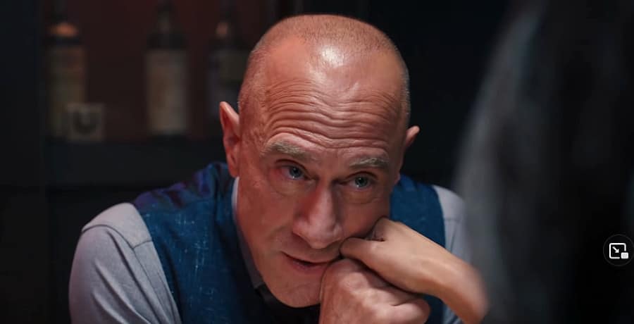 A bald man kissing a woman's hand