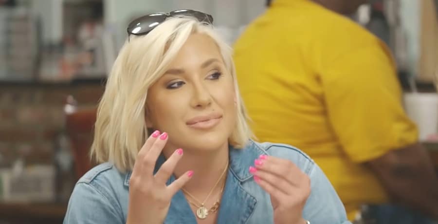 A woman with blonde hair and pink nail polish