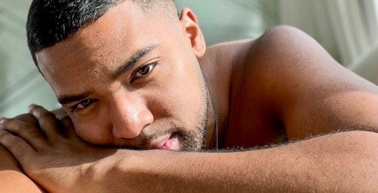 A black man with his shirt off, looking right at camera