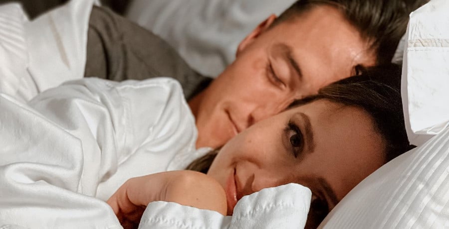 A man and a woman laying in bed together 
